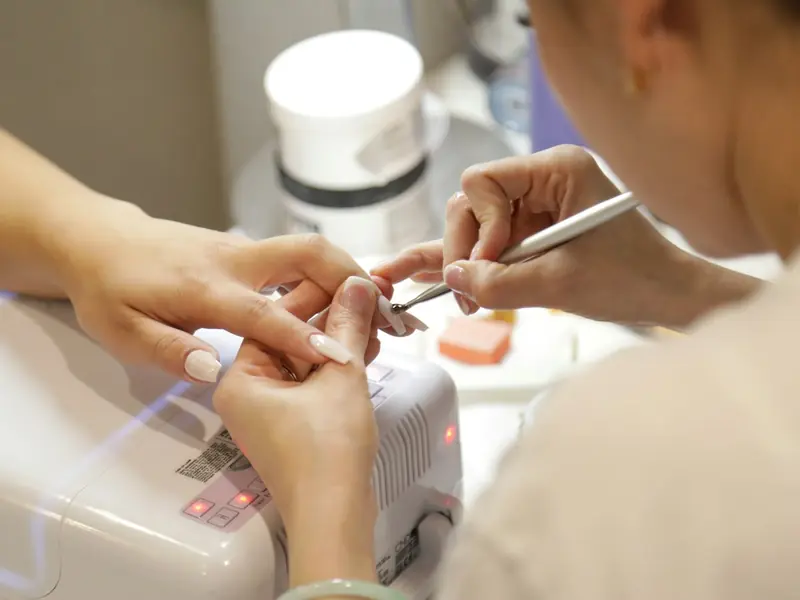 A nail technician working on a client’s nails